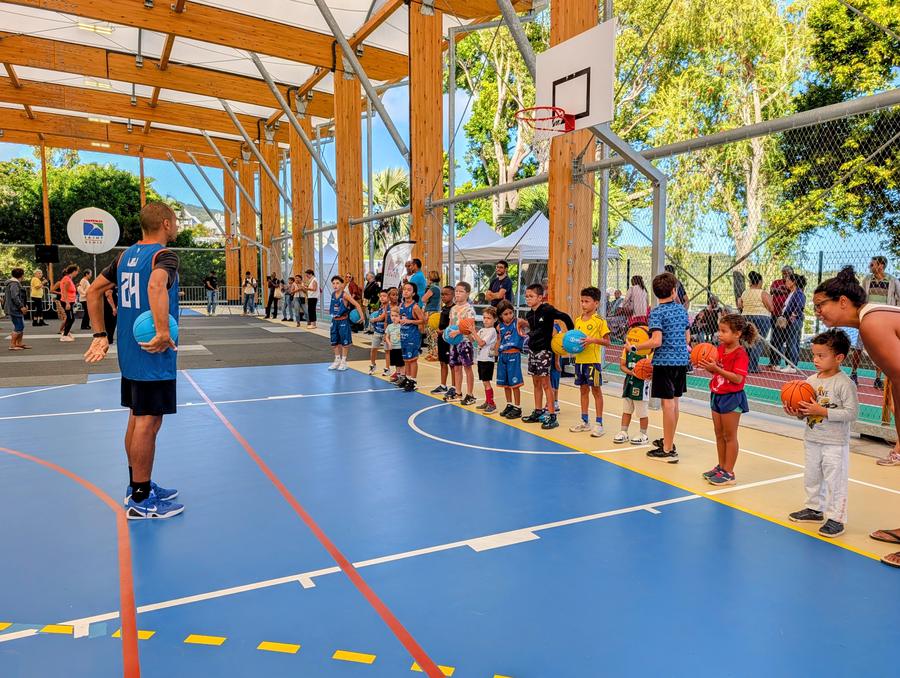 Un coach du MBC face aux enfants du quartier venus découvrir le basket, sur le terrain couvert de La Montagne à Saint-Denis.