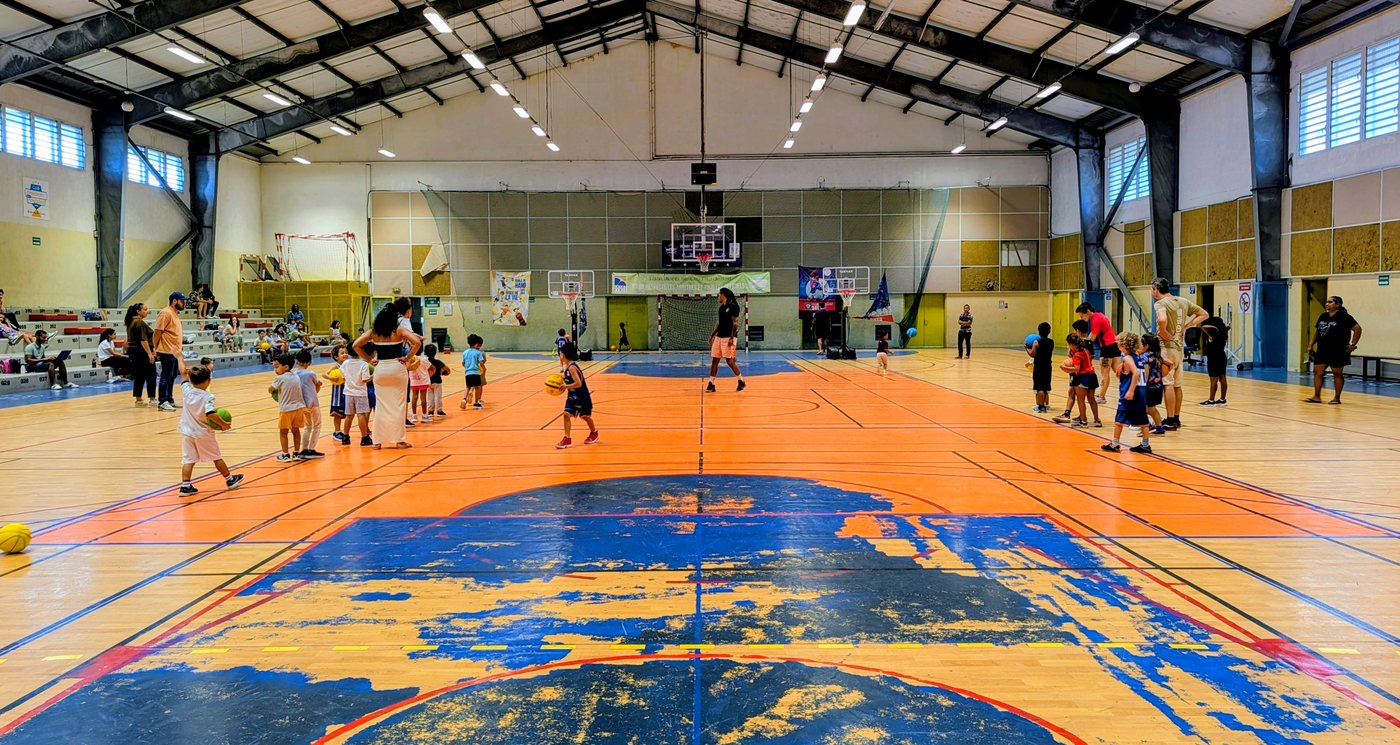 Le gymnase de La Montagne pendant l'école de basket : deux groupes d'enfants en atelier de part et d'autre du terrain, à Saint-Denis.