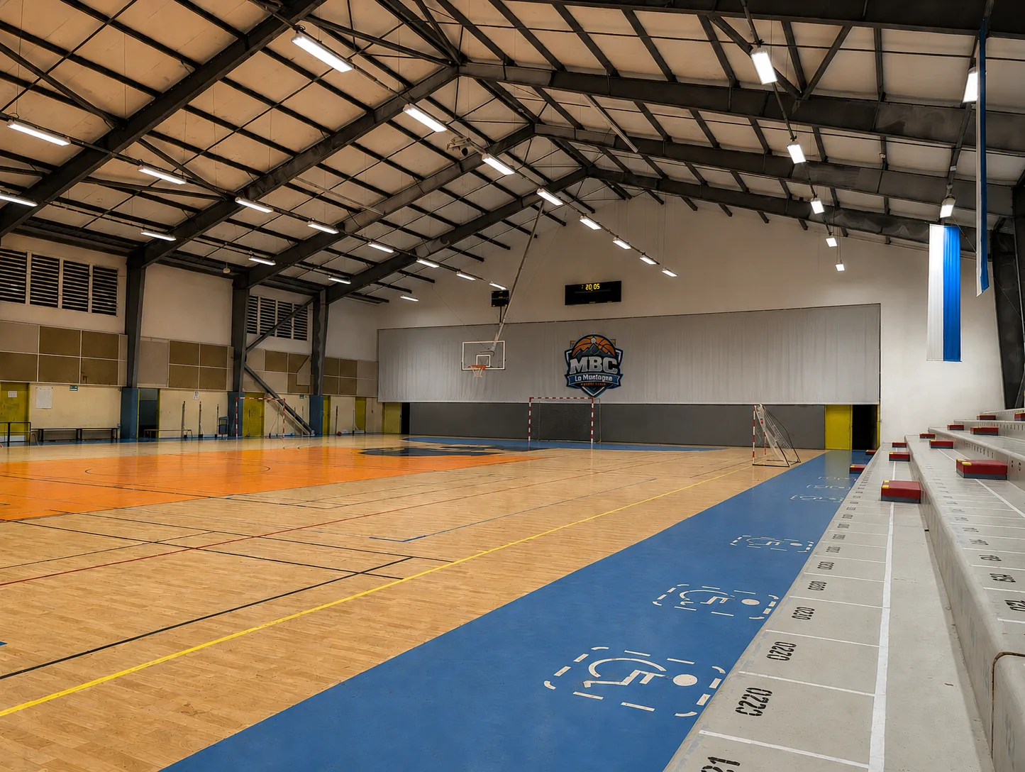 Intérieur du Gymnase de La Montagne, salle du MBC La Montagne Basket Club, avec le logo du club au mur et le terrain de basket